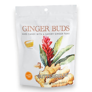 The image displays a white packet of BUTTERFIELDS - GINGER BUDS hard candy. The front features an illustration of a ginger plant with red flowers and green leaves. The text reads "Ginger Buds" and "Gluten Free," highlighting its natural ginger flavor, with the net weight shown as 2.5 oz (60 grams).