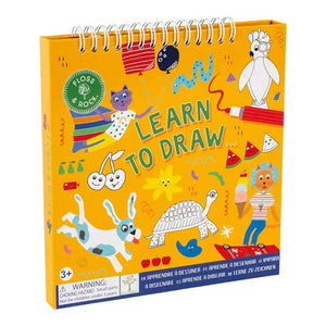 The FLOSS & ROCK PETS LEARN TO DRAW kit by FLOSS & ROCK is open, revealing a step-by-step guide for drawing a cat. On the left side, the illustration process with markers is depicted, while the right side displays a finished cat drawing on a decorated page. This vibrant and travel-friendly art kit guarantees creative fun wherever you go!