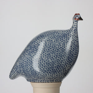 Handmade in the South of France, three guinea hens from Les Ceramiques de Lussan appear alongside a ceramic mug. The largest is 24 cm, the medium 20 cm, and the small 17 cm; all stand against a gray background with French labels. The mug's height is 8.5 cm.