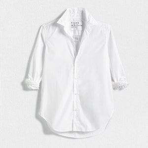 A FRANK AND EILEEN - FRANK CLASSIC BUTTON-UP SHIRT SUPERFINE POPLIN in white, featuring a classically tailored long-sleeve design with rolled-up sleeves, is displayed against a plain, textured background. The label inside the collar reads "FRANK & EILEEN." This shirt offers a classic, slightly relaxed fit with a curved hemline and bust-flattering button placement.