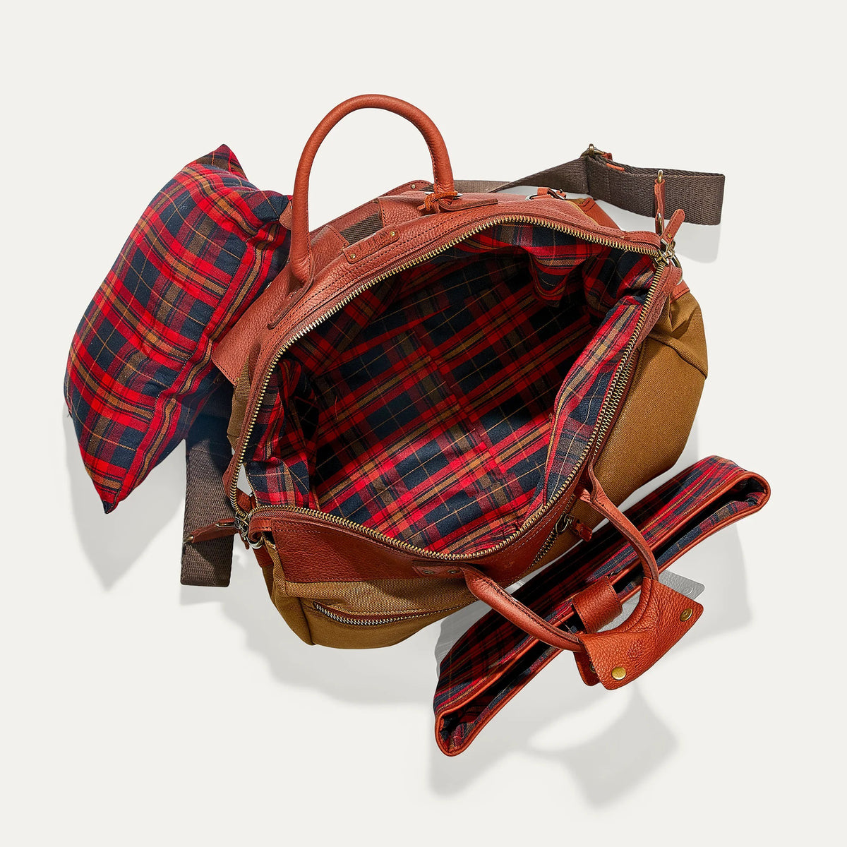 The WILL LEATHER GOODS Canvas and Leather Duffel in Tobacco/Cognac is open to show its roomy interior with a red and black plaid lining. Two matching plaid accessories from WILL LEATHER GOODS are displayed beside the bag.