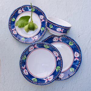 The VIETRI - MELAMINE CAMPAGNA DINNER PLATE by VIETRI features a decorative border with blue and white birds, red tulips, and green leaves on a vibrant orange background. The central section of the plate is plain white, and the border also includes a blue rim, ensuring durability while adding charm to your table.