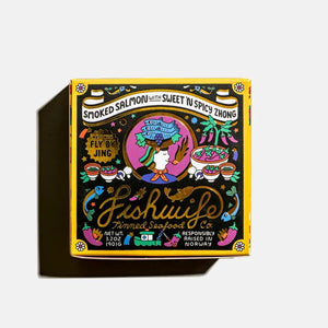 A square red tin of "FISHWIFE - SMOKED SALMON WITH SWEET & SPICY ZHONG" is displayed against a white background. The colorful label features a woman holding a fish, along with the text "Hand Packed" and "Sustainably Caught," and decorative illustrations of ropes and fish. This edition also highlights the partnership between Fishwife and Fly By Jing, adding a touch of the Sweet + Spicy Zhong flavor.