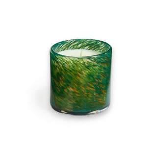 The LAFCO Woodland Spruce Holiday Candle, featuring a hand-blown glass vessel embellished with green and gold speckles, holds a soy wax candle against a plain white backdrop.