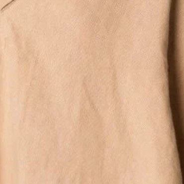 Close-up of LOESS's IRENA LINEN DRESS in beige, showcasing its smooth texture with subtle creases and natural folds. The soft, matte fabric embodies the essence of slow fashion.