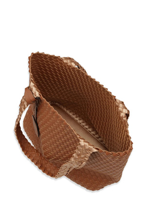 The WOVEN REVERSIBLE TOTE BAG by LINES OF DENMARK is a brown woven-texture tote with faux-leather accents, offering two styling options. It features two handles and includes a leather tag attached to one handle for added versatility.