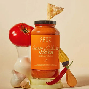 A jar of SAUZ - Creamy Calabrian Vodka Sauce is displayed against a white background. The label is orange with white and yellow text, highlighting it as a rich and creamy vodka sauce infused with Calabrian Chilis. The product weight is specified as 24.5 ounces.