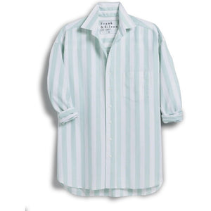 The FRANK & EILEEN Silvio Untuckable Button-Up Shirt in Wide Stripe Sage Oxford features fashionable light blue and white stripes, long sleeves partially rolled up, and an oversized envelope pocket on the left chest, set against a plain background.