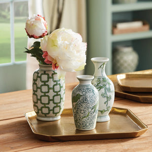 The NAPA HOME AND GARDEN - IMPERIAL BUD VASE collection includes three handcrafted white ceramic vases with green designs: branches and flowers, geometric patterns, and a bird on floral motifs, adding refined elegance to any space.