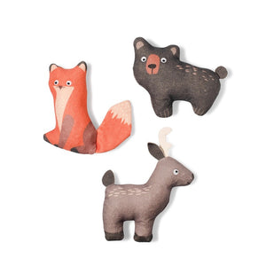 A corgi with a black and brown coat stands on a beige background, holding the PET SHOP BY FRINGE STUDIO's charming FRINGE STUDIO - FOREST FRIENDS MINI DOG AND CAT TOYS, crafted from durable cotton canvas and resembling a whimsical cartoonish character. Another mini pet toy rests on the ground nearby. The small dog gazes up with an eager expression.