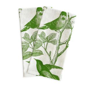 The CASKATA - Arbor Birds Kitchen Towel in Green features two folded fabric napkins with a green botanical print of birds on leafy branches over a white background, perfect as kitchen linens or charming Mother's Day gifts.