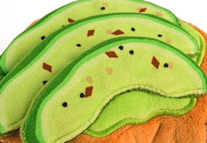 The BARKING BRUNCH MINI AVOCADO TOAST from PLAY PET LIFESTYLE is an adorable plush toy designed to resemble a slice of toast topped with green avocado slices, complete with black seeds and red pepper flakes. This brunch-themed pet toy features a small fabric tag on the right side, making it one of the most durable and charming options available for your furry friend.