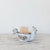 The CREATIVE COOP STONEWARE CHICKEN SHAPED BOWL is a ceramic bowl designed like a chicken with detailed tail, wings, and comb. It has a glossy finish in white and brown due to its reactive glaze, making it perfect as a quirky kitchen sponge holder.