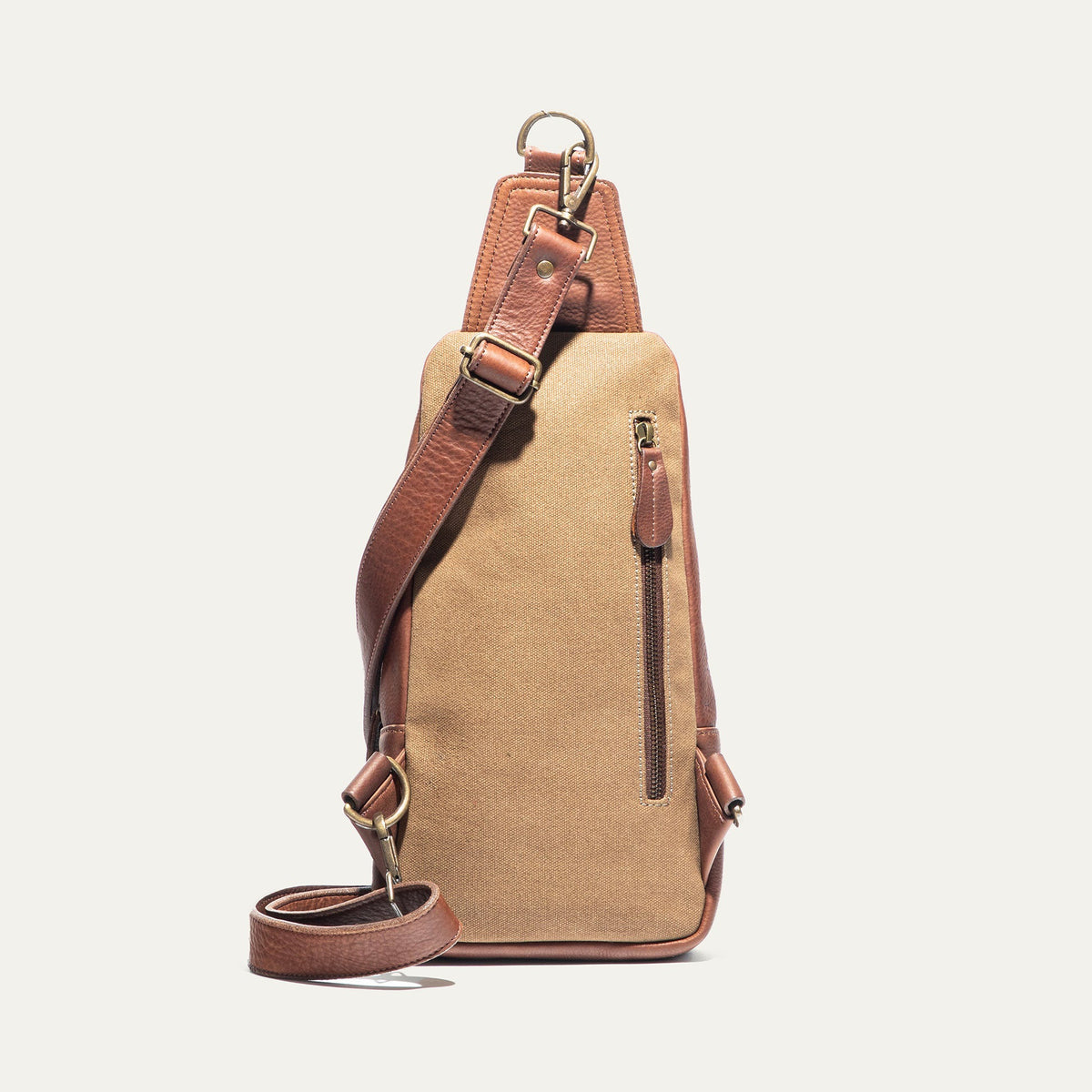 The WILL LEATHER GOODS - ZIP AROUND SLING BAG by WILL LEATHER GOODS is a brown full-grain leather sling bag with a zippered design, front zipper pocket, adjustable strap, and visible stitching, displayed upright on a white background.