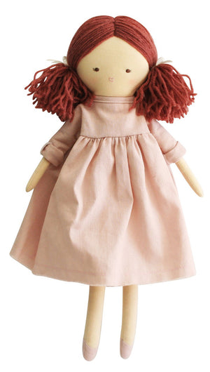 The ALIMROSE - MATILDA DOLL PINK by ALIMROSE is a soft fabric doll with dark red yarn hair styled in pigtails and an embroidered face. She is dressed in a light pink linen dress with long sleeves and matching pink shoes. The removable dress allows for easy outfit changes, adding to the fun.