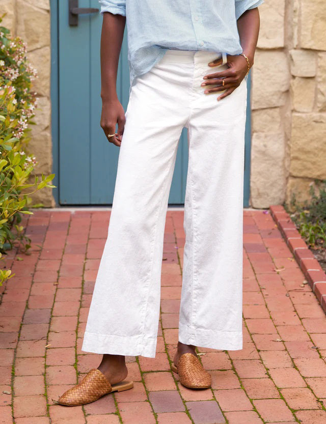 The FRANK AND EILEEN - WEXFORD WIDE LEG LINEN TROUSER IN WHITE from FRANK &amp; EILEEN is a stylish pair of wide-leg pants made from lightweight Italian Performance Linen. These white trousers feature a mid-rise waist, a concealed front zipper, and side pockets, all with a straight and relaxed fit that extends to the hem.