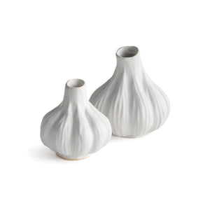 The NAPA HOME AND GARDEN - ALBURY BUD VASE features two white ceramic vases on a plain white background. Their reactive glaze, bulbous shapes, and narrow openings resemble garlic bulbs, showcasing the artisan's craftsmanship.