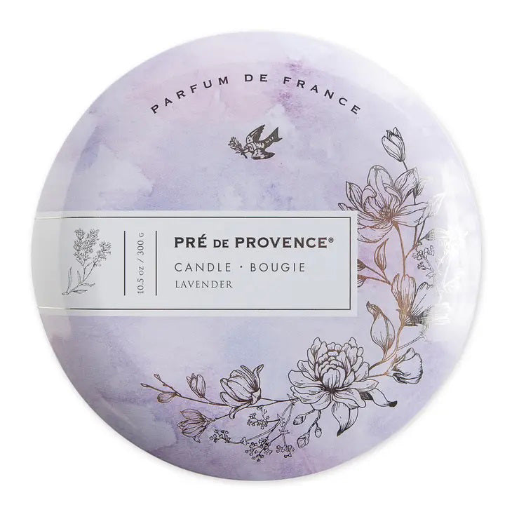 A round 3 Wick Candle - Lavender from European Soaps, LLC, featuring delicate floral illustrations in purple and white tones. The label includes &quot;Pré de Provence,&quot; &quot;Candle,&quot; and &quot;Lavender,&quot; along with a &quot;Parfum de France&quot; inscription and an image of a bird, perfect for enhancing your home ambience.