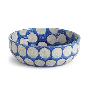 The NAPA HOME AND GARDEN - KILEY BOWL IN BLUE is a cobalt blue ceramic piece with large, textured white polka dots evenly spaced, both inside and out, evoking mid-century pottery. Its wide, rounded design makes it a striking centerpiece for any table.