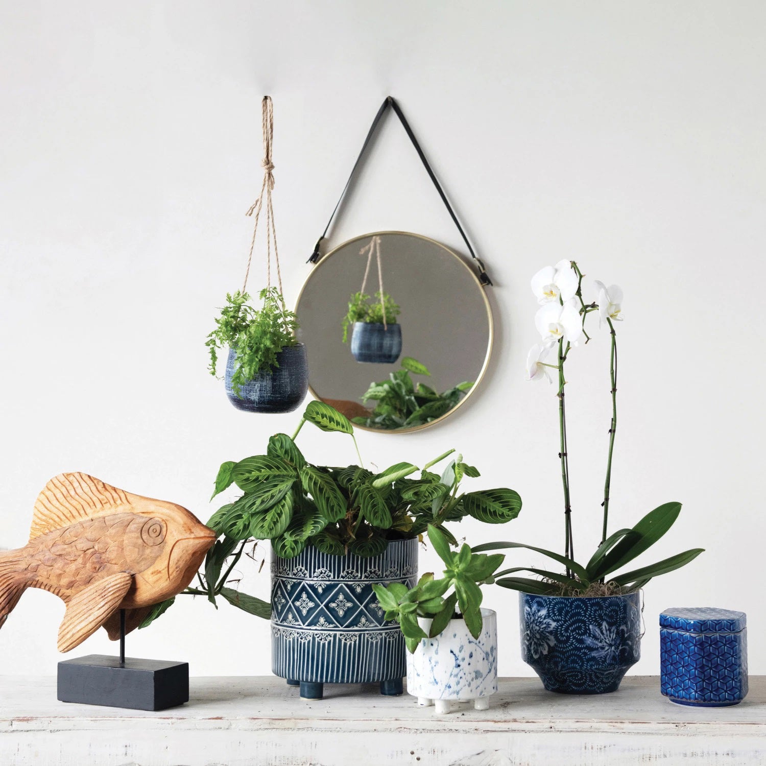 The BLUE STONEWARE PLANTER by CREATIVE COOP features a dark blue and white design, showcasing intricate floral prints with swirling patterns across its surface. This rounded base planter has a subtle textured finish and a slightly wider opening at the top, making it perfect for home decor.