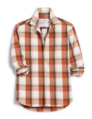 The FRANK & EILEEN Eileen Relaxed Button Up Shirt in Italian Flannel Pumpkin Plaid is a long-sleeved, button-up design featuring a flattering button placement at the bust and a classic collar. It showcases an orange, white, and brown plaid pattern with stylishly rolled-up sleeves. Additionally, the brand label is visible on the inside of the collar.