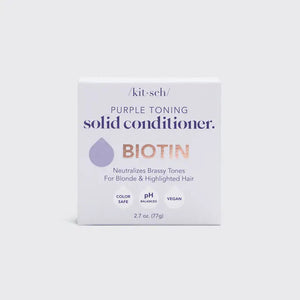 A light purple solid conditioner bar sits atop a white rectangular box. The box, labeled "KITSCH Purple Toning Solid Conditioner Bar," highlights that the biotin-infused product, weighing 2.7 oz (77g), neutralizes brassiness in blonde and highlighted hair.