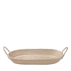 The BASKET CHANGING TABLE by OLLI ELLA USA is a large, oval, woven basket featuring two handles on either end. Ideal for use as a changing basket or for nursery decor, it is crafted from light-colored natural fibers that give it a rustic and earthy appearance. The tight and uniform weave pattern ensures a sturdy base and sides, providing both durability and aesthetic appeal. The basket is empty.