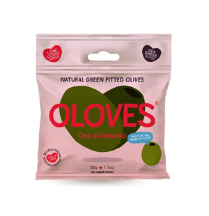 A small, light pink packet of POSHI brand olives named OLOVES - CHILI & OREGANO. The package features the text "Natural Green Pitted Olives" and "Chili & Oregano" with a green olive illustration. Labels indicate it's a low-calorie, gluten-free vegan snack with a new Greek recipe. Net weight: 30g / 1.1 oz.