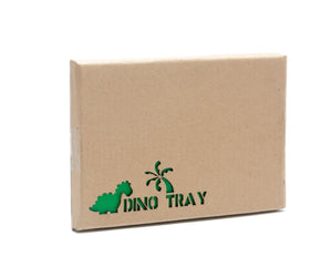 The WOOD DINOSAUR PLAY TRAY by BEST YEARS LTD is a vibrant children's wooden puzzle that features an array of fair-trade dinosaur toys and trees within a green rectangular frame. One blue dinosaur piece adorned with pink spots rests outside the frame. The puzzle includes sustainable wooden dinosaur toys in red, green, orange, and blue hues.