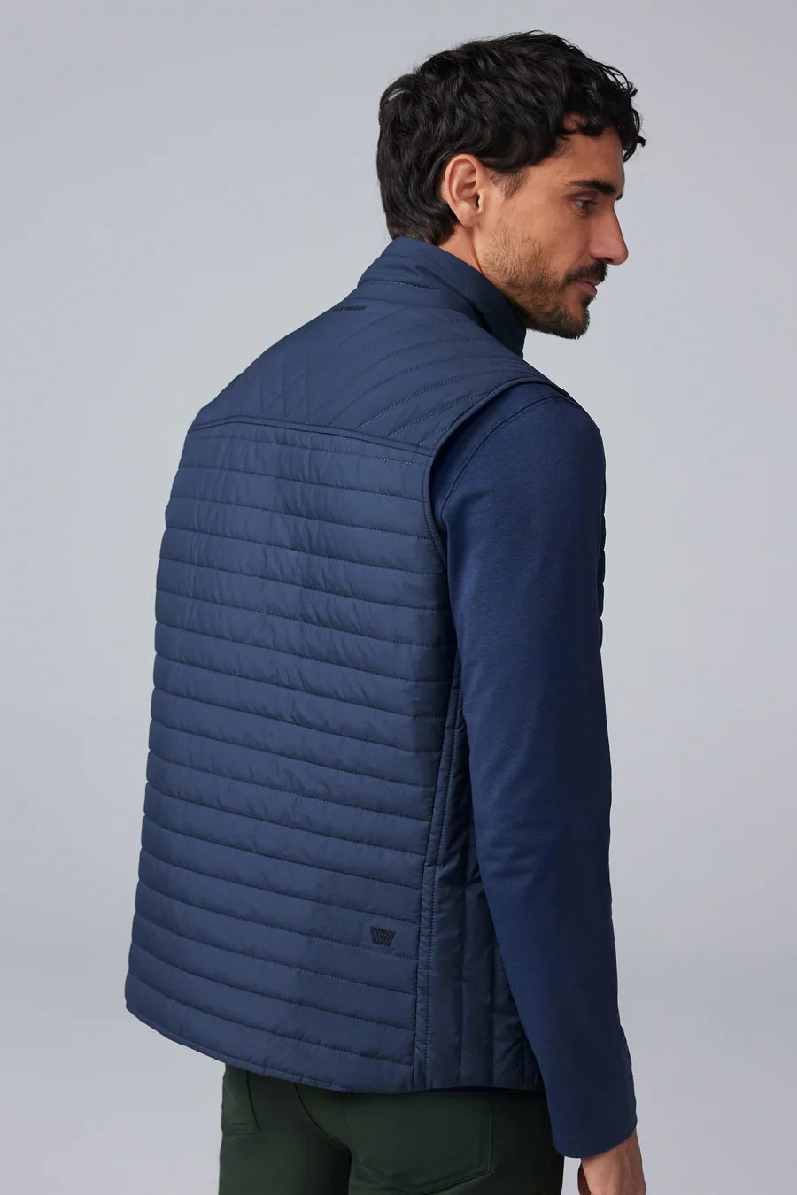 The MACK WELDON - WARMKNIT AIR PUFFER VEST is a sleeveless, dark navy vest with Thinsulate fill, high collar, snap-button front, and horizontal quilting, shown laid flat on a white background.