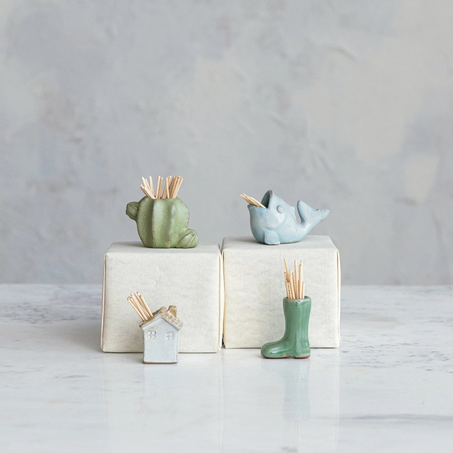 A small, green CREATIVE COOP GARDEN BOOT TOOTHPICK HOLDER shaped like a single garden boot, standing upright against a plain white background.