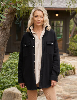 Presenting the Frank & Eileen McLoughlins Utility Jacket: a black, long-sleeve garment with a collared neckline and button-down front. It boasts two chest pockets with button closures and slightly rolled-up sleeves for a touch of California-cool. The label on the inside collar proudly displays "Frank & Eileen," set against a plain, textured white background.