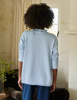 The FRANK & EILEEN Monterey Rolled Funnel Neck Sweater in Ice is crafted from Italian cotton and features rolled cuffs, a relaxed fit, and long sleeves. This light blue turtleneck is displayed on a plain white background and is machine-washable for easy care.