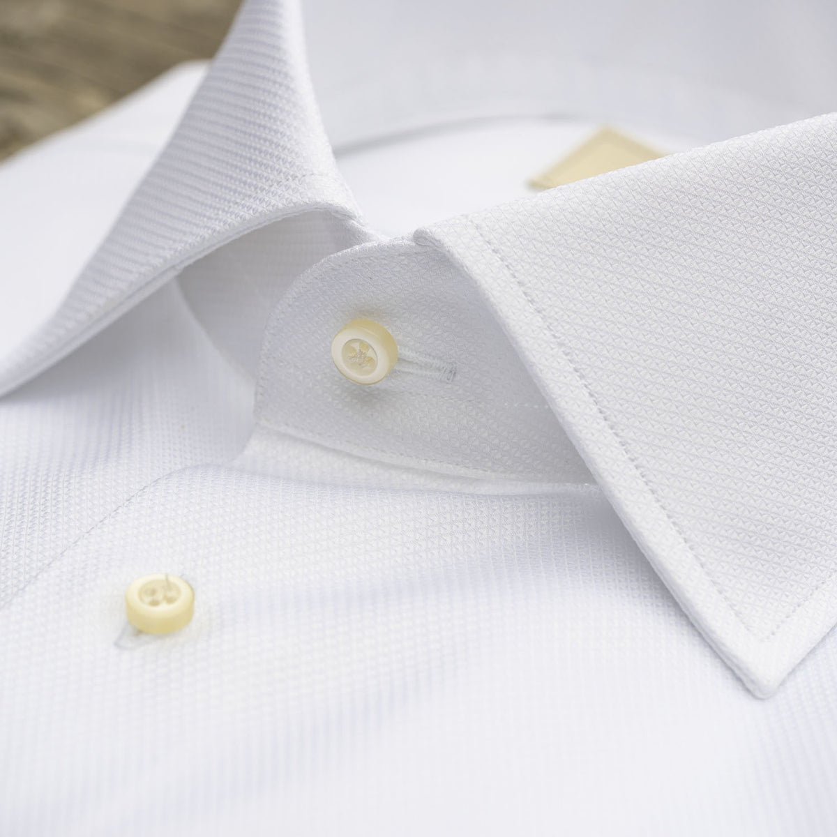 A crisp white HAGEN formal dress shirt in Italian cotton dobby, featuring a pointed collar, French cuffs, and the &quot;HAGEN&quot; label inside the collar.