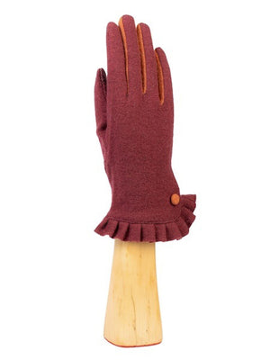 A KNIT WOOL AND CASHMERE GLOVE WITH RUFFLE from the SANTACANA MADRID WORLD GLOVE COMPANY is showcased on a wooden hand model, featuring teal cashmere with dark pink accents between the fingers and a decorative ruffled cuff adorned with a pink button.