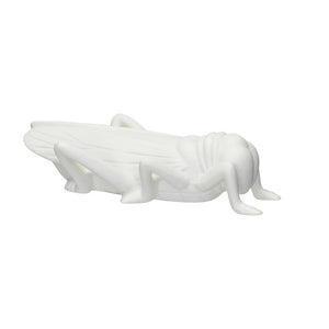 The STONEWARE BISQUE GRASSHOPPER PAPERWEIGHT by CREATIVE COOP features a detailed white stoneware sculpture of a grasshopper, showcasing intricate wings and legs, lying on its side against a plain white backdrop.