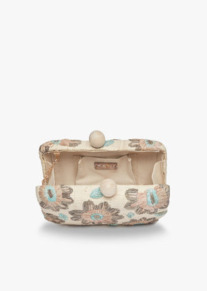 The KAYU - BRYN CLUTCH from KAYU is a rectangular fabric clutch with beige and blue floral patterns on a cream background. It features an elegant clasp made of two beige spherical knobs, adding charm reminiscent of a wooden ball clasp.