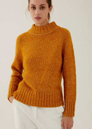 Close-up image of the ANNECLAIRE - Mock Turtleneck Heathered Cotton and Wool Sweater, showcasing its high-quality knit by ANNECLAIRE with detailed interwoven yarns and a textured pattern. The knitting technique creates an elegant, soft, and cozy look, with the yarn strands intertwined to form a uniform, slightly bulky surface.