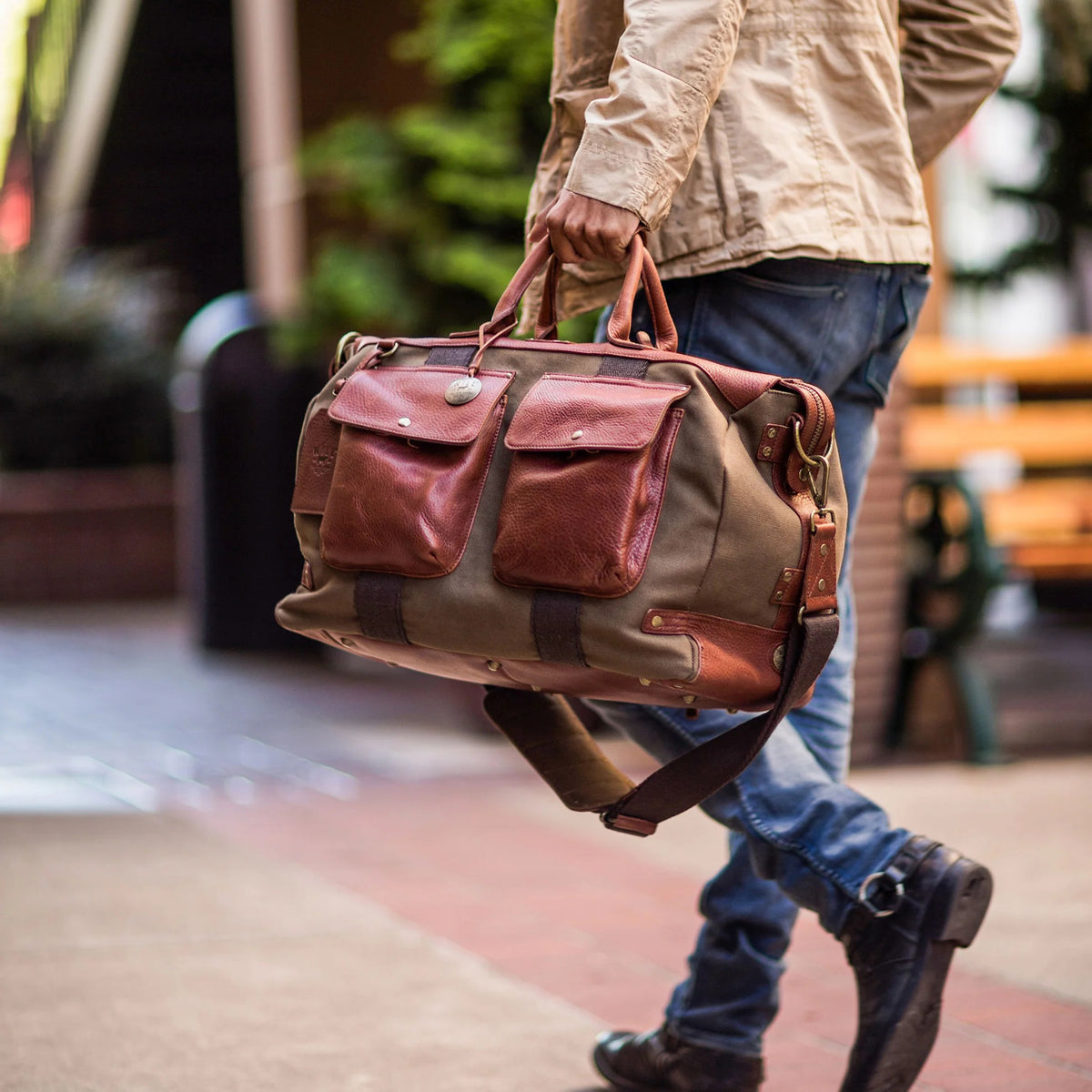The WILL LEATHER GOODS Canvas and Leather Duffel in Tobacco/Cognac is open to show its roomy interior with a red and black plaid lining. Two matching plaid accessories from WILL LEATHER GOODS are displayed beside the bag.