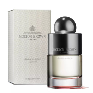 A bottle of MOLTON BROWN - GINGERLILY EAU FRAICHE is placed in front of its white packaging box. The sleek design of the perfume bottle, adorned with a shiny round cap, evokes the allure of a Polynesian lagoon. The box features the Molton Brown logo and product details.