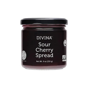 A jar of DIVINA - SOUR CHERRY SPREAD from Gourmet Food Solutions, featuring a black lid. The label indicates the net weight as 9 ounces (255 grams), and the product is verified as non-GMO. This exquisite Mediterranean jam is set against a white background.
