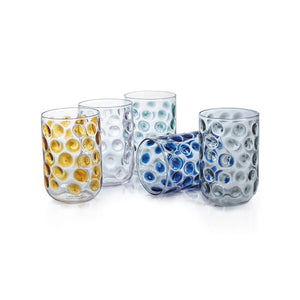 Five **AIRELLES GLASS TUMBLERS** by **ZODAX**, adorned with textured bubble patterns and distinct colored accents in blue, green, amber, clear, and pink. Each glass boasts a 460 ml capacity and is elegantly displayed on a light-colored fabric surface against a neutral background.