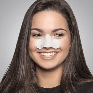 A young woman with long, straight brown hair smiles while wearing a SUNSET STRIP from STARSKIN on her nose. The background is a plain gray, emphasizing her focus on pore cleansing.