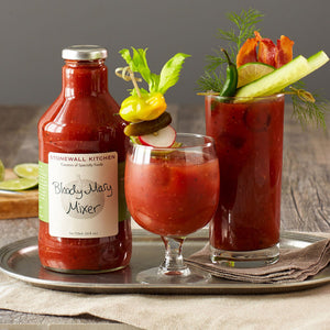 A bottle of STONEWALL KITCHEN - BLOODY MARY MIXER is displayed with a silver cap and a white label featuring green text. This gourmet mixer is gluten-free and non-GMO, containing 24 fluid ounces (710 milliliters) of product—perfect for your next brunch gathering.