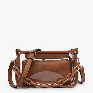 Introducing the CLEAR CROSSBODY BAG by JEN & CO: A stylish handbag crafted from vegan leather, showcasing a layered beige design with an open top and a visible zipper pocket. This bag is elegantly framed by a transparent outer layer and is complemented by a chunky beige chain strap for additional style and versatility.