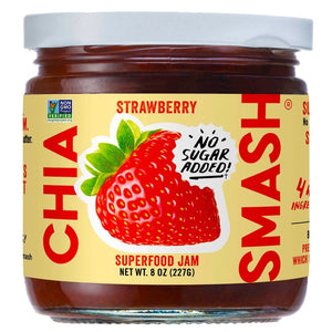 A jar of CHIA SMASH - STRAWBERRY CHIA JAM with zero added sugar. The jar boasts a red lid and a label showcasing a large strawberry illustration, along with the text "No Sugar Added!" and "Non-GMO Project Verified" certification. Made from upcycled fruit, this 8 oz (227g) jam is both paleo and vegan friendly.