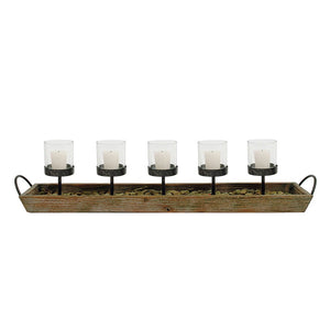 The CREATIVE COOP VOTIVE HOLDER serves as a decorative centerpiece, consisting of a rectangular wooden tray with metal handles. It includes five glass votives, each elevated on black metal stands and surrounded by small pebbles at the base—ideal for adding fireplace ambience to any room.