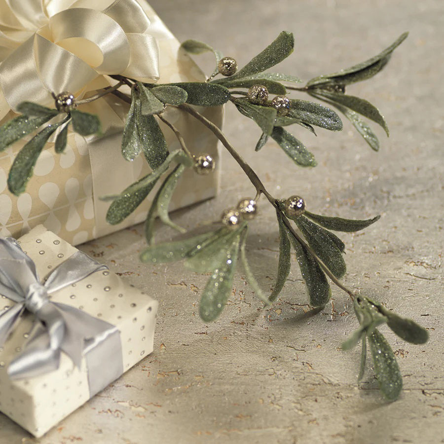 Introducing the Olive and Berry Holiday Stem by Zodax, featuring lush matte green leaves and delicate silver berries beautifully contrasted against a white background. This elegant piece is perfect for bringing a festive touch to any setting, with dimensions thoughtfully designed to complement your home decor's natural charm.