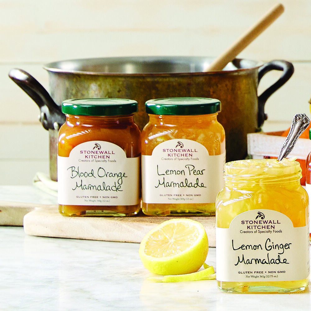 A jar of STONEWALL KITCHEN - LEMON GINGER MARMALADE, weighing 361g (12.75 oz). The label highlights it is gluten-free, non-GMO, and made with cane sugar. This lemon marmalade boasts a vibrant yellow color with delightful ginger pieces throughout.