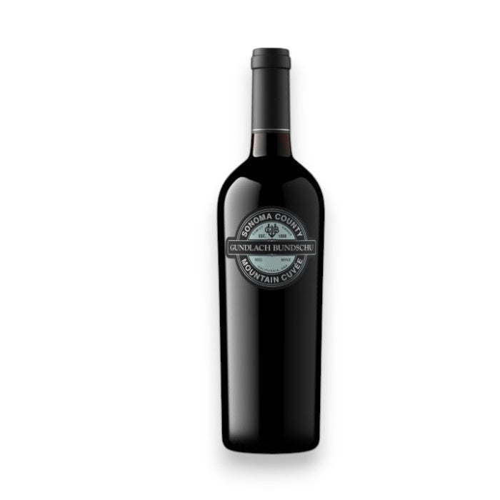 A dark glass wine bottle with a black &quot;GUNDLACH-BUNDSCHU &#39;MOUNTAIN CUVEE&#39; CAB-MERLOT 2023&quot; label by WINE: TRYON is displayed against a white background, highlighting this Sonoma Valley red blend.